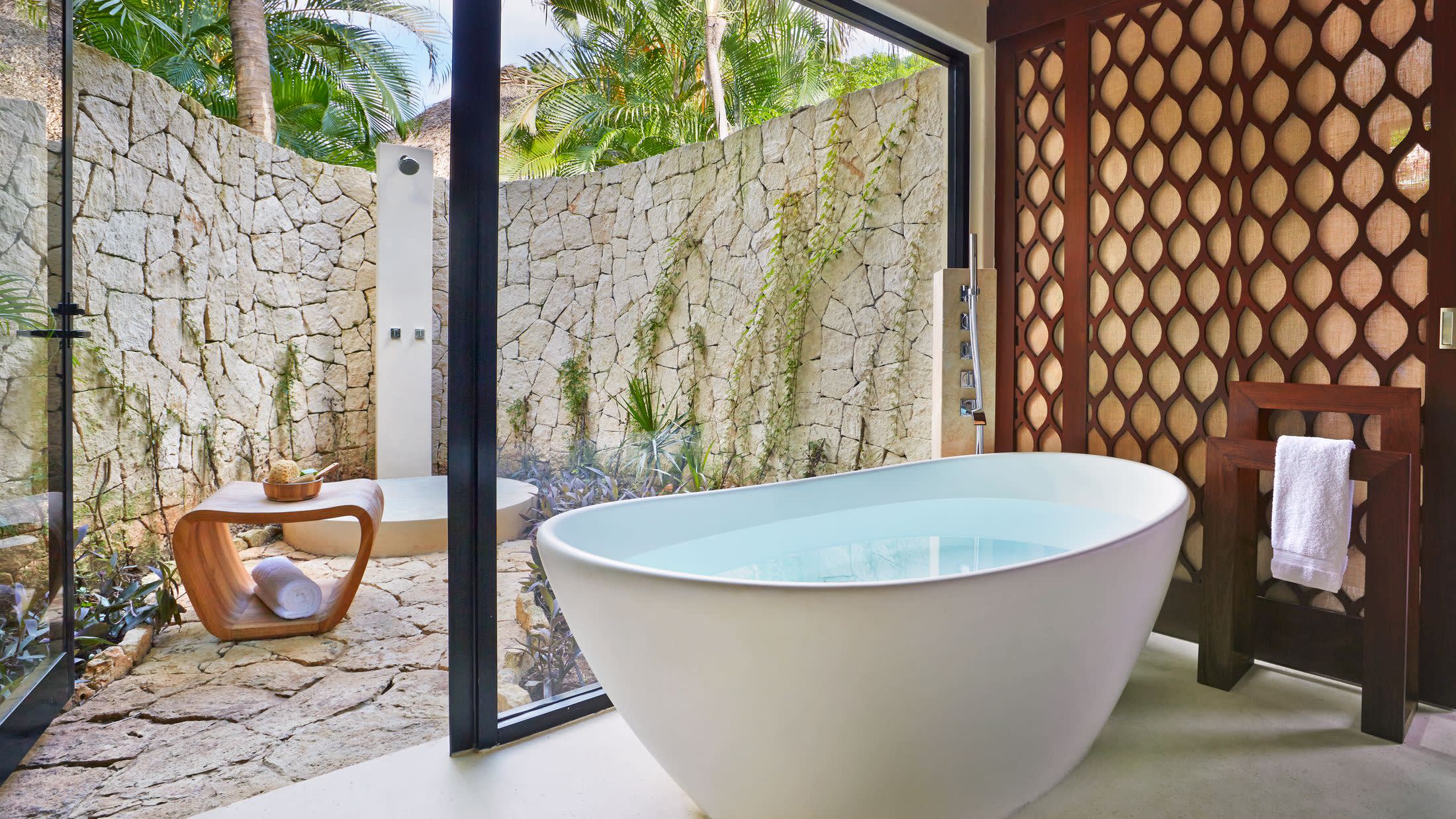 a large white tub sitting next to a stone wall