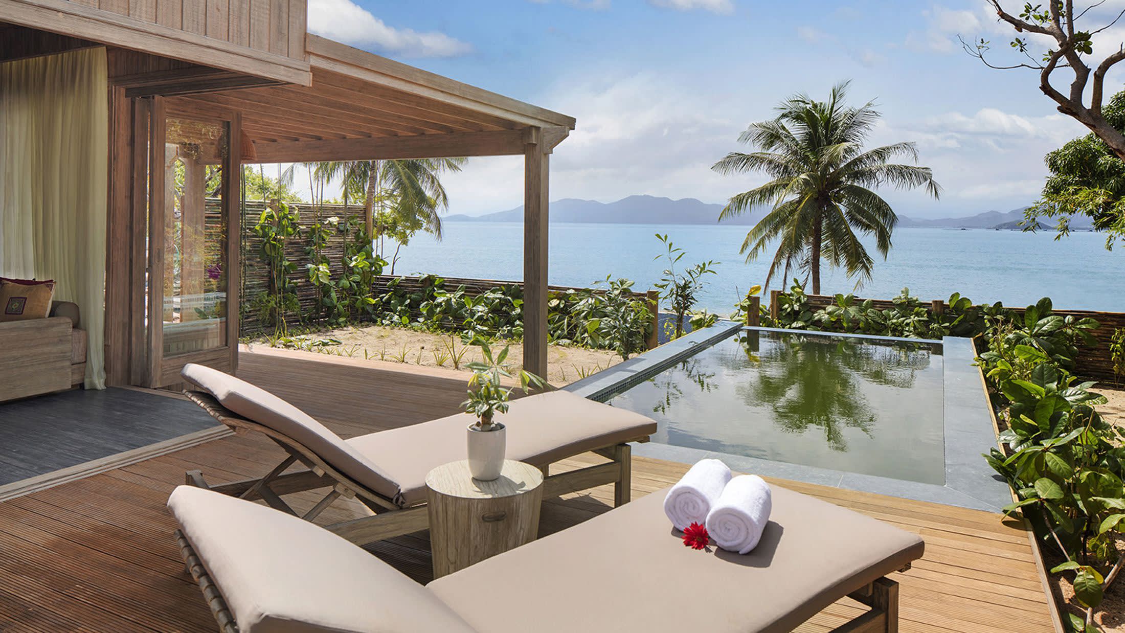 a hotel room with a couch and table in a garden