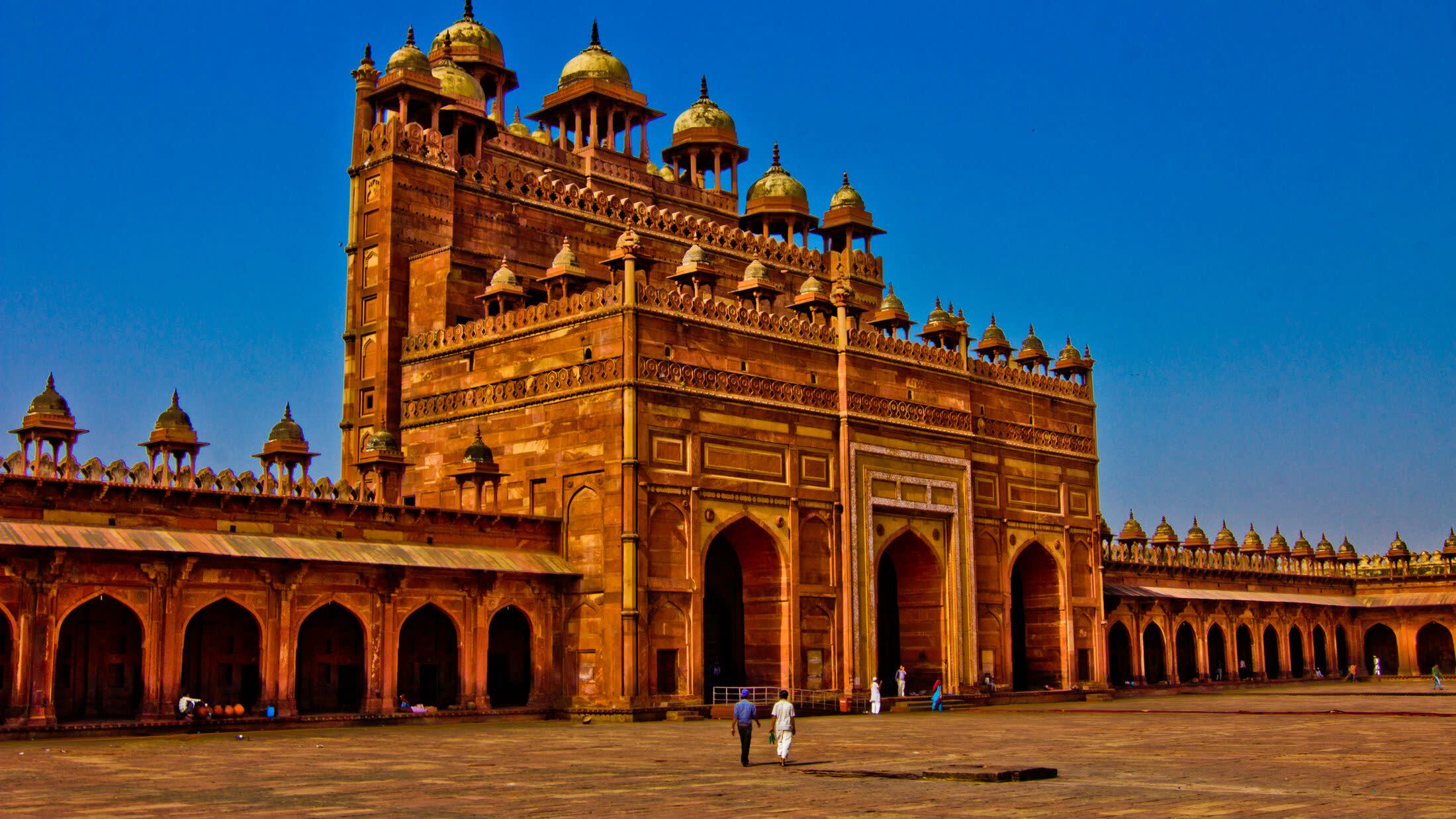 a large stone building with Fatehpur Sikri in the background