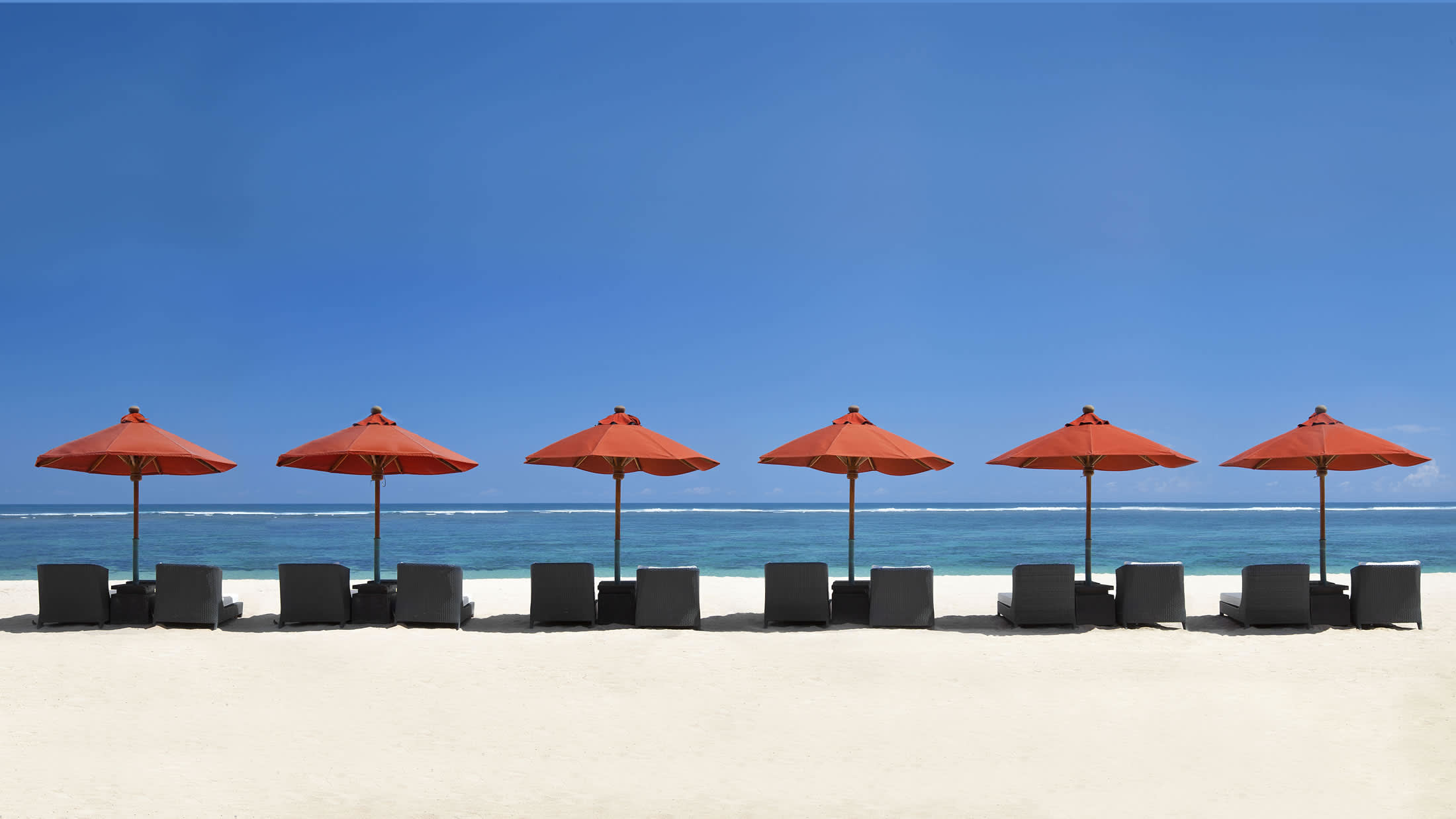 a row of beach chairs and an umbrella