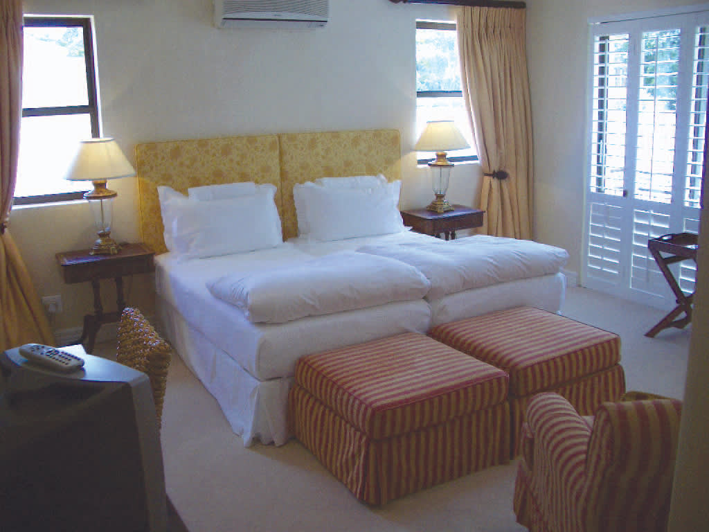 a bedroom with a bed and a chair in a room