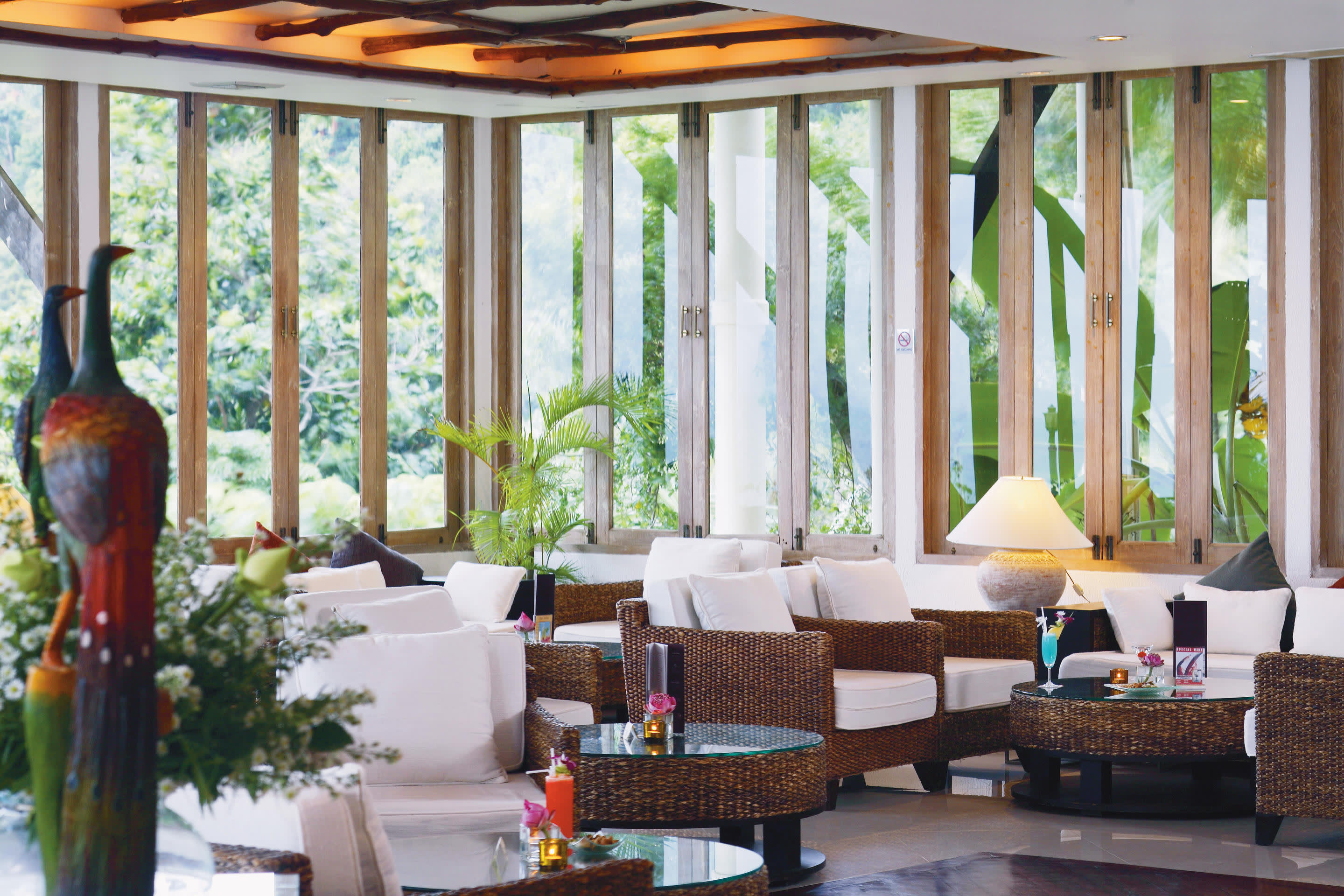 a living room filled with furniture and vase of flowers on a table