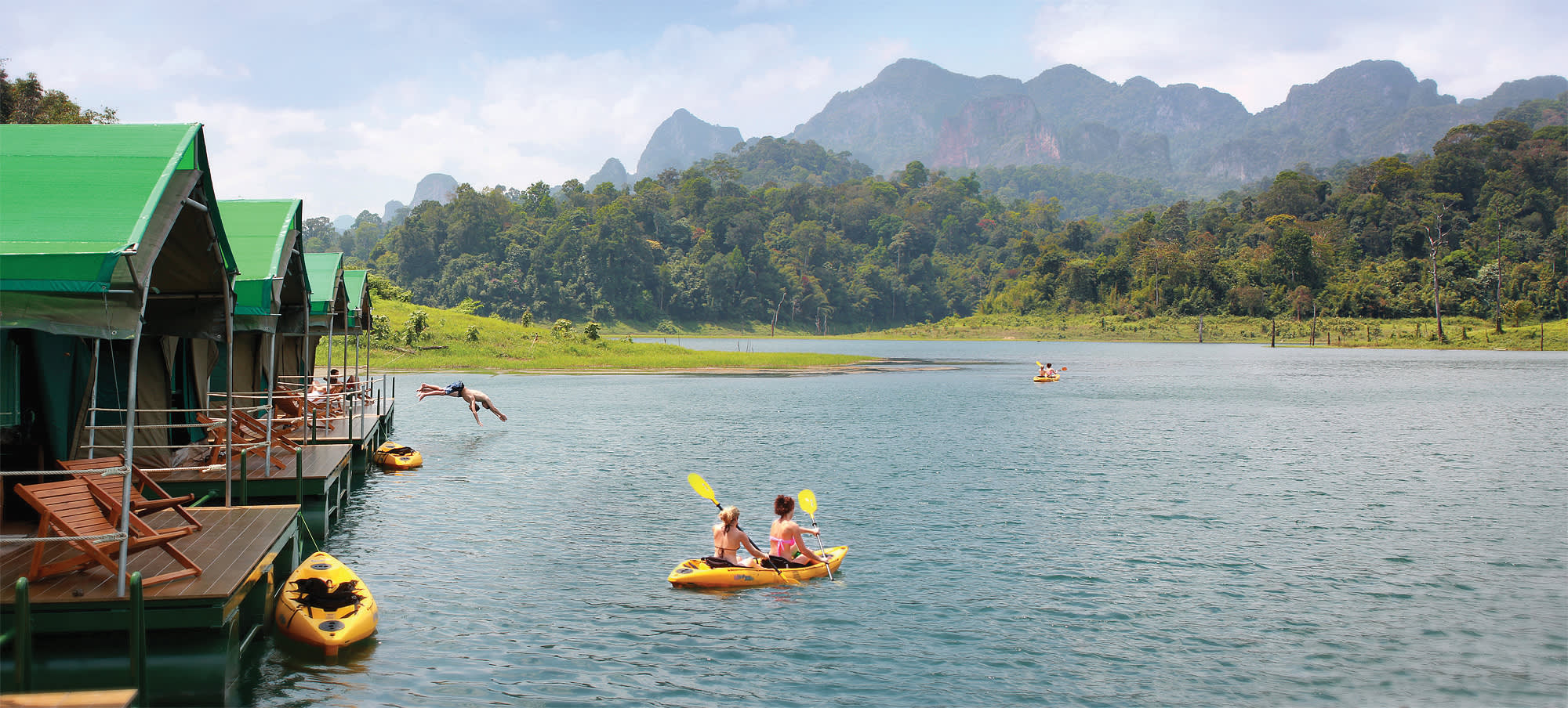 a small boat in a body of water with Li River in the background