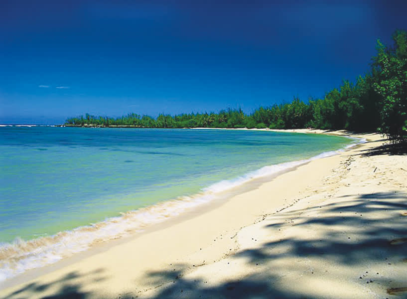 a sandy beach next to a body of water