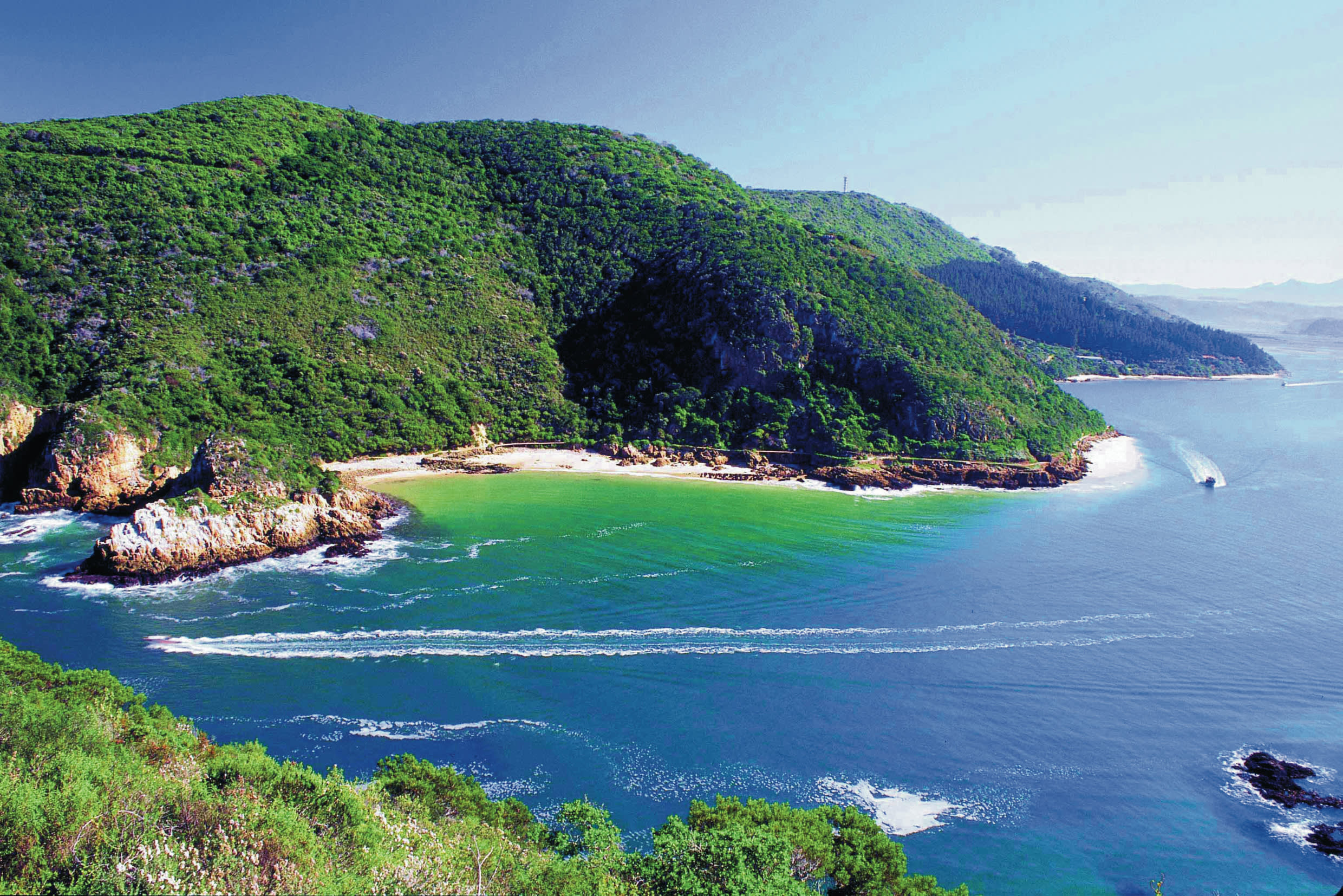 a body of water with a mountain in the ocean