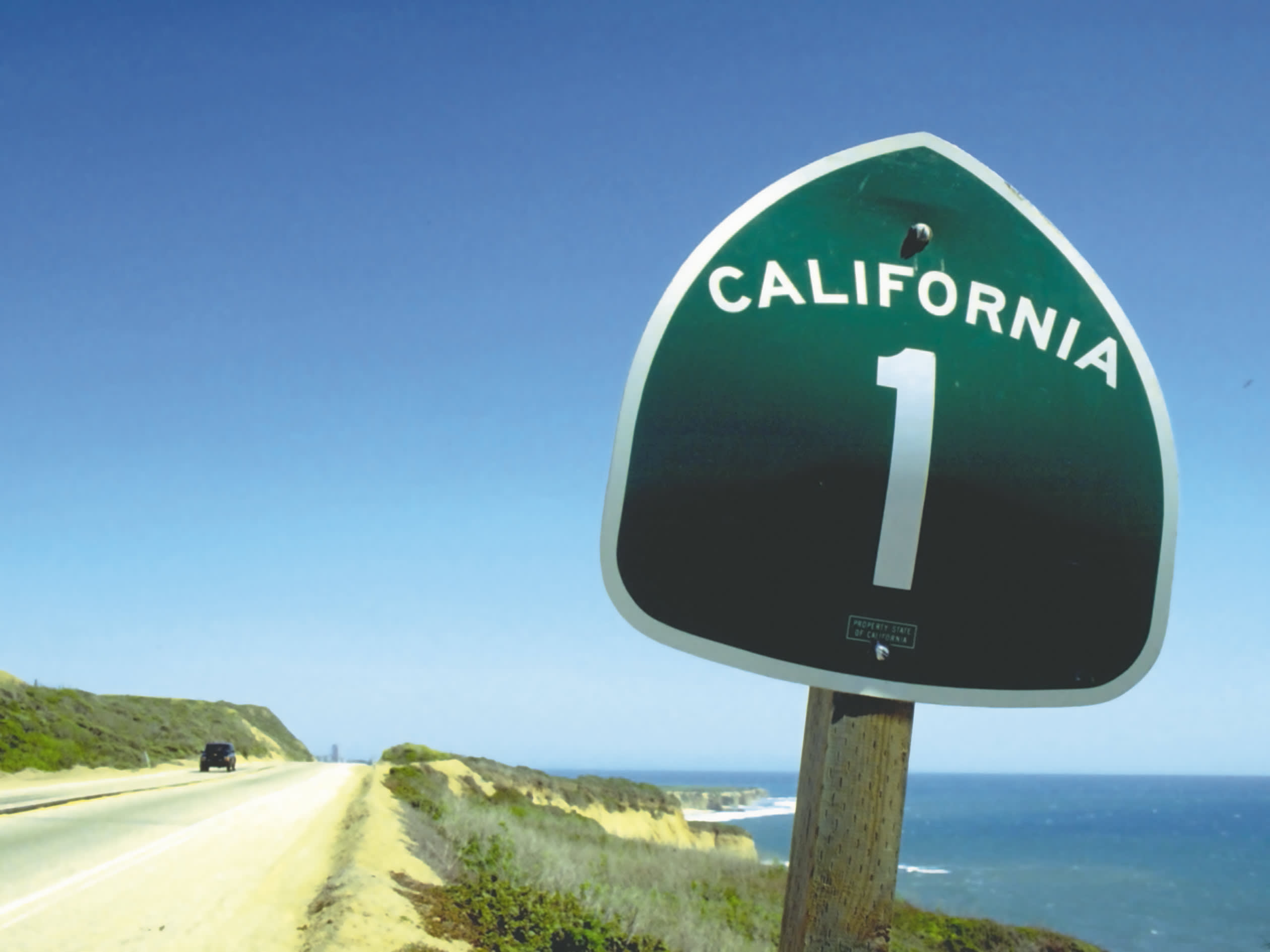 a close up of a street sign sitting on the side of a road