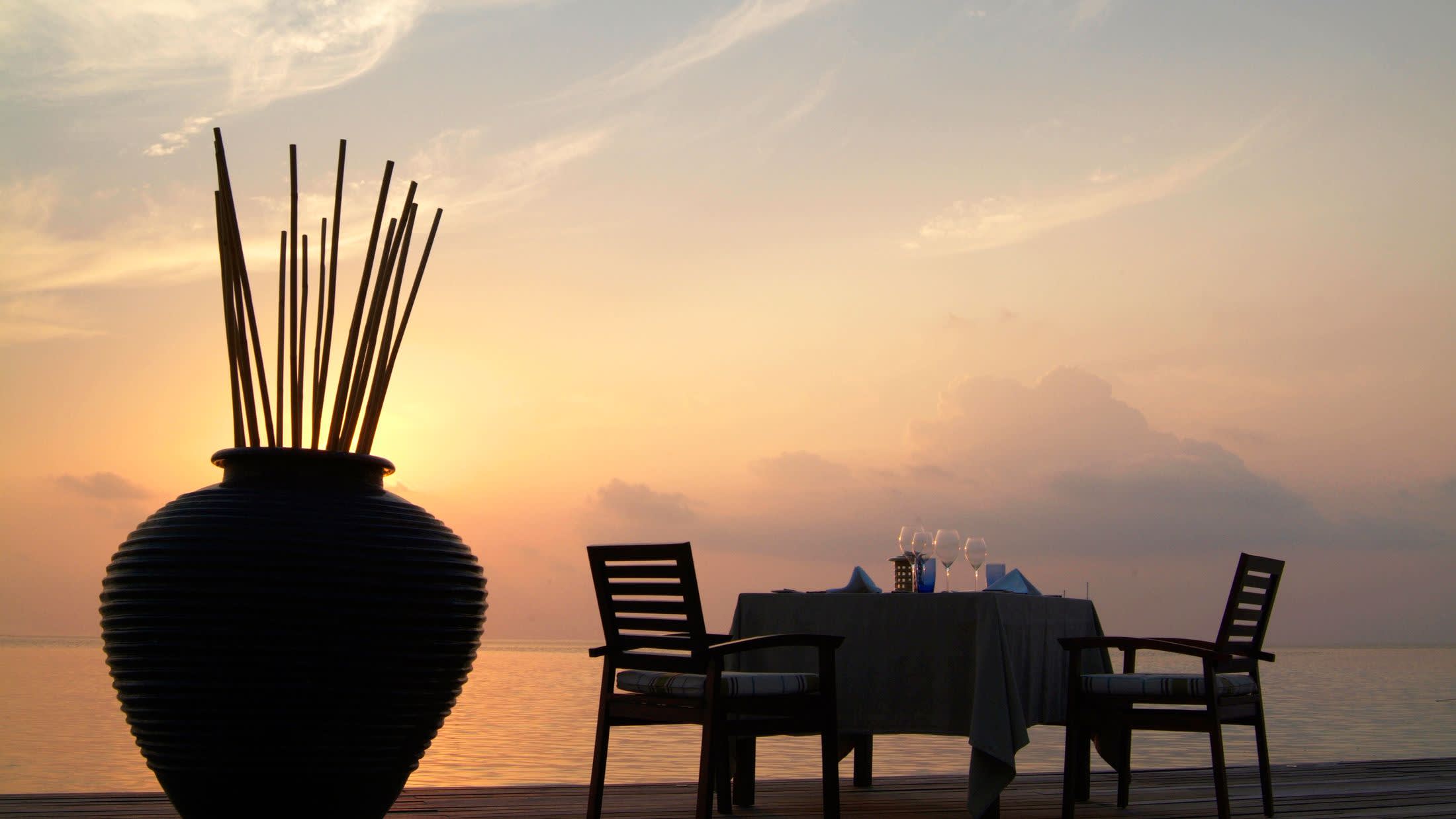 a chair sitting in front of a sunset