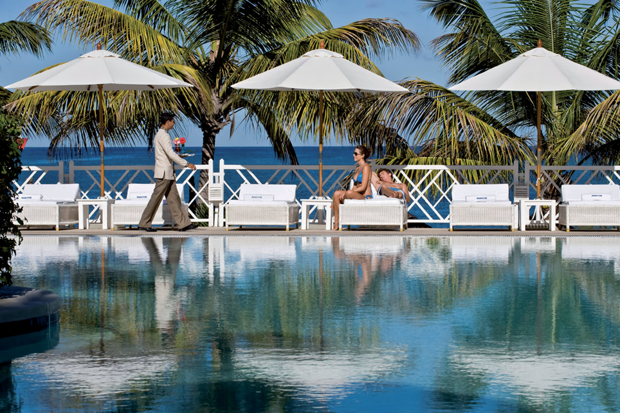 a resort near the water lined with palm trees