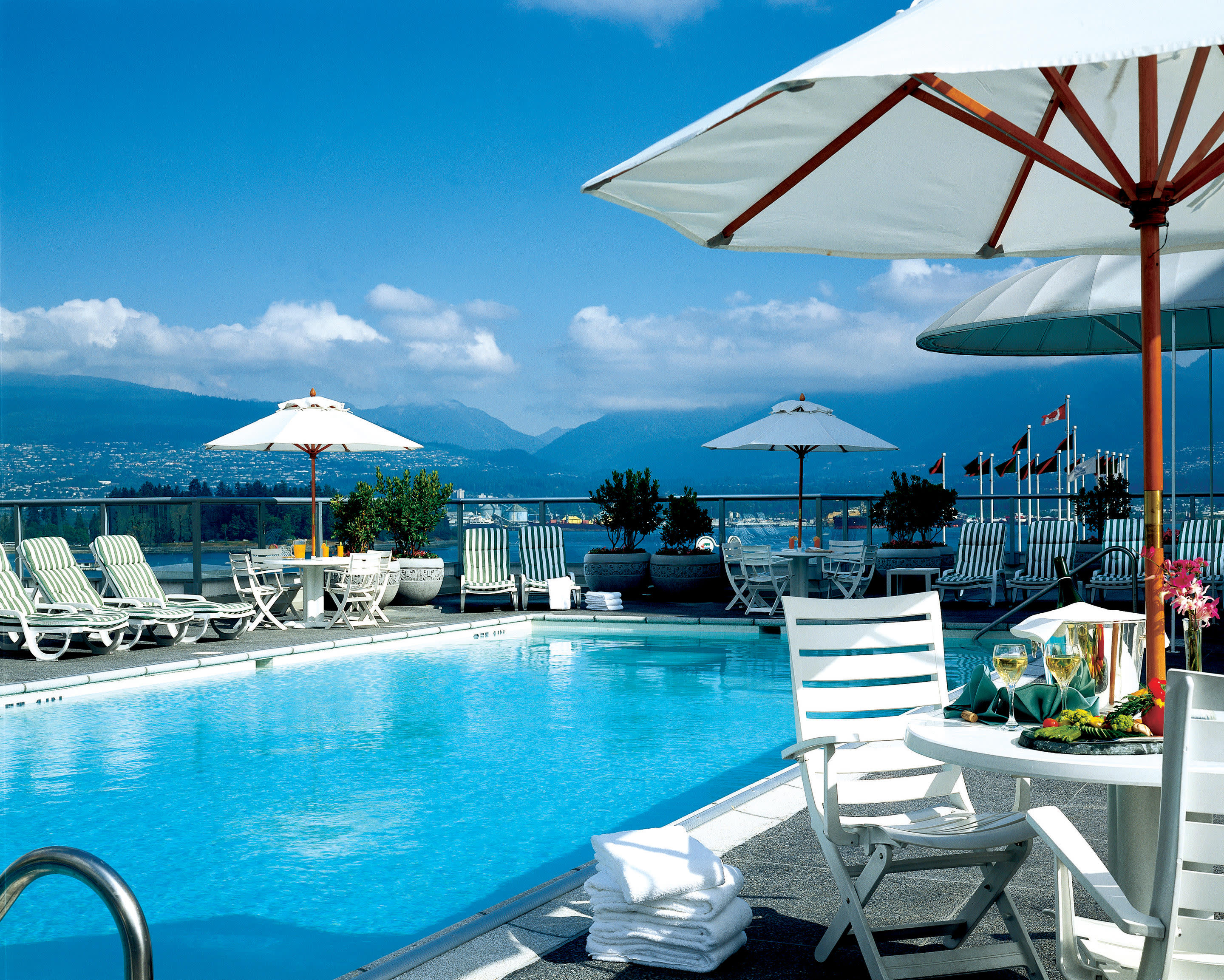 a group of people sitting at a table with a blue umbrella