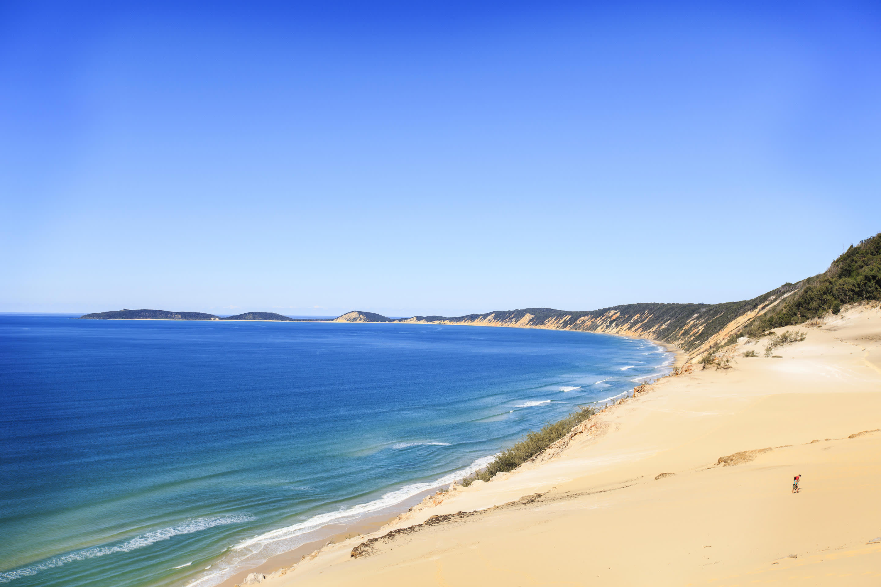 a sandy beach next to a body of water