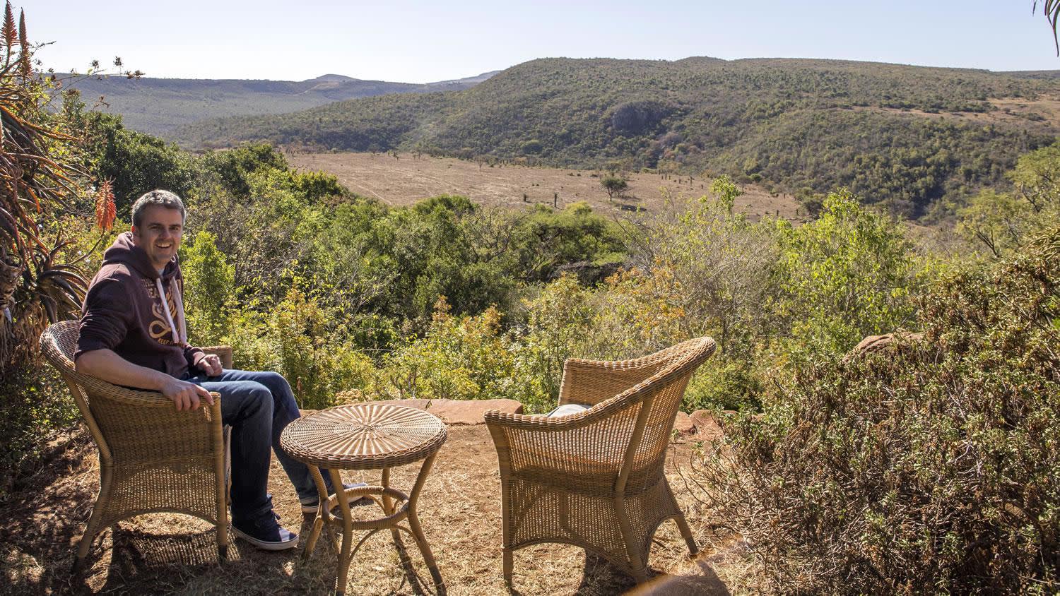a man sitting on a bench in front of a mountain