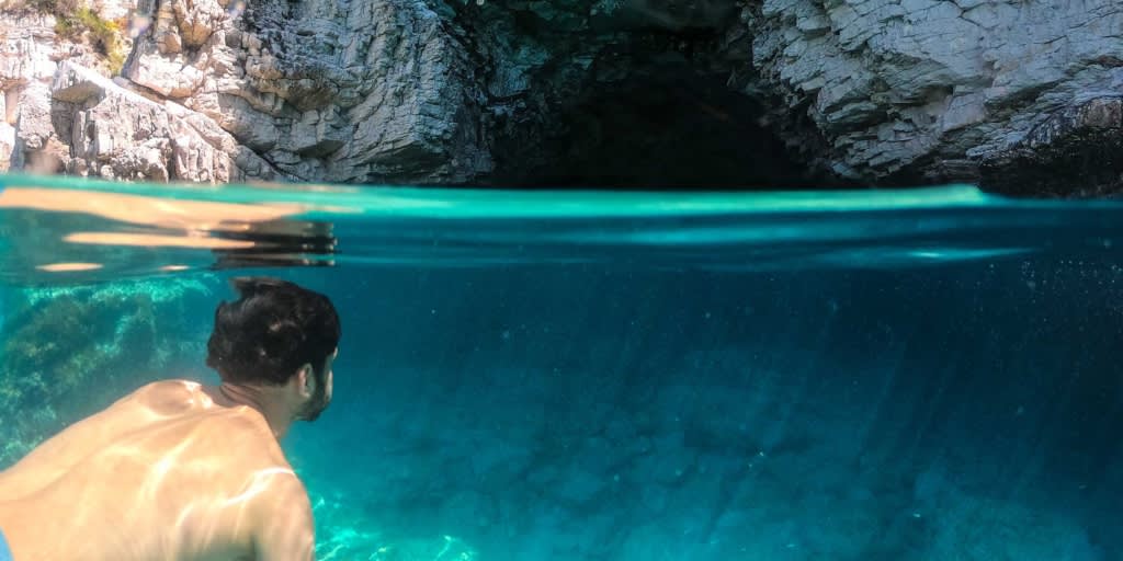 Mann schwimmt außerhalb der Blauen Lagune in Korfu, Griechenland