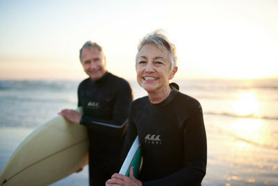 Couple carrying surfboards