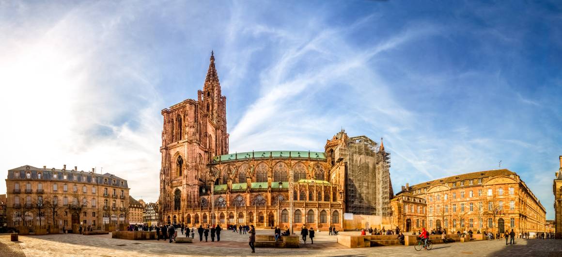 Vue grand angle de la cathédrale Notre‑Dame de Strasbourg et de la place avoisinante par une journée ensoleillée.