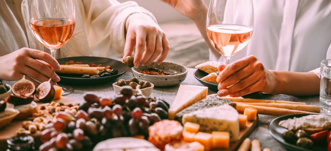 A close-up of a charcuterie board with French cheese, olives, figs, and wine, evoking the gourmet pleasures of a Canal du Midi boating holiday in France.