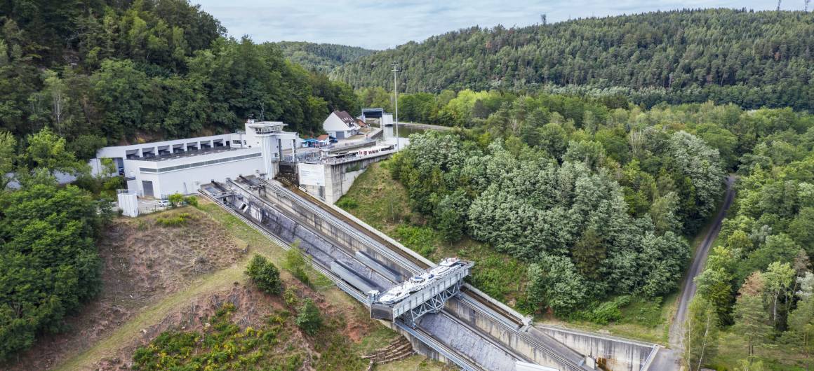 Vue aérienne du plan incliné d’Arzviller, entouré de forêt, avec un bateau de plaisance entrant dans l’ascenseur.