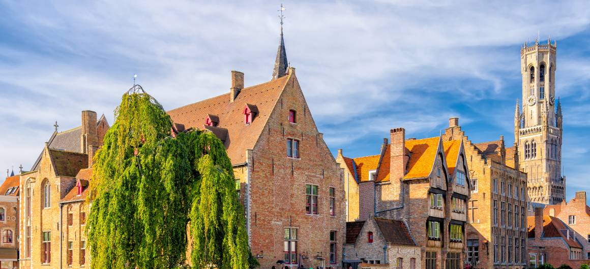 Classic view of Bruges’ canal with colourful buildings and medieval belfry, scenic highlights of Flanders.