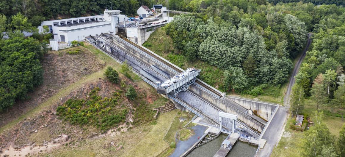 Aerial view of the Arzviller inclined boat lift with surrounding forest and a canal boat entering the boat lift.