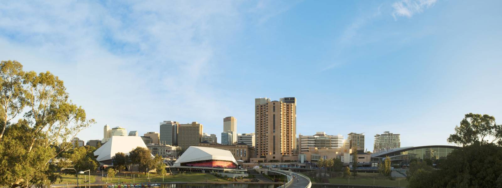 a bridge over a body of water with a city in the background