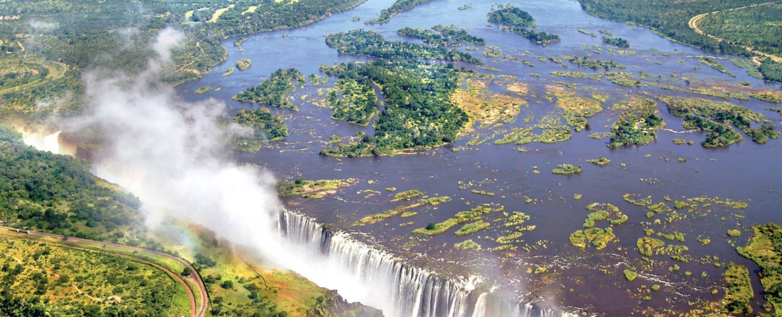 Vy över forsande Victoriafallen och regnbåge, Zimbabwe
