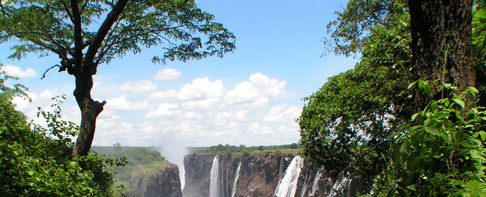 Forsande vattenmassor i Victoriafallen genom regnskog, Zimbabwe