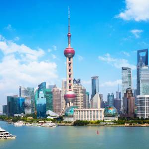 Blick vom Wasser auf die Skyline von Shanghai vor der Kulisse eines blauen Himmels