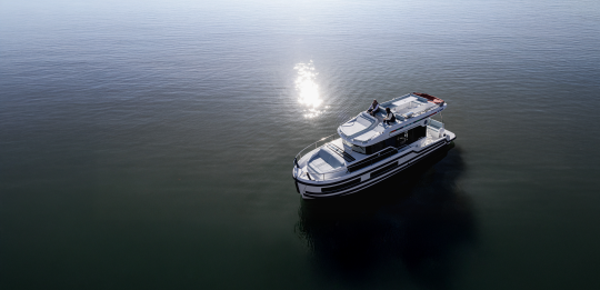 Le Boat’s Liberty cruising on calm water under the sun, with two passengers enjoying the view from the top deck.