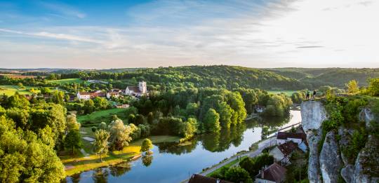 Wanderer genießen die Aussicht von einer Klippe über einem gewundenen Fluss und einem bewaldeten Tal in Burgund.