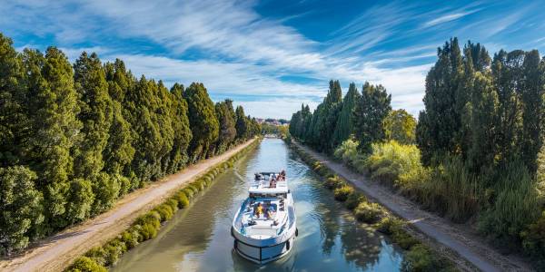 Un bateau navigue le long du pittoresque canal du Midi, offrant une manière paisible et relaxante de découvrir le sud de la France.
