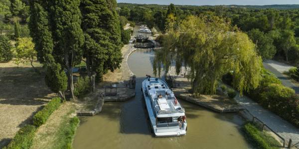 Una barca si avvicina a una chiusa tradizionale lungo il Canal du Midi, offrendo un'autentica esperienza di navigazione francese.