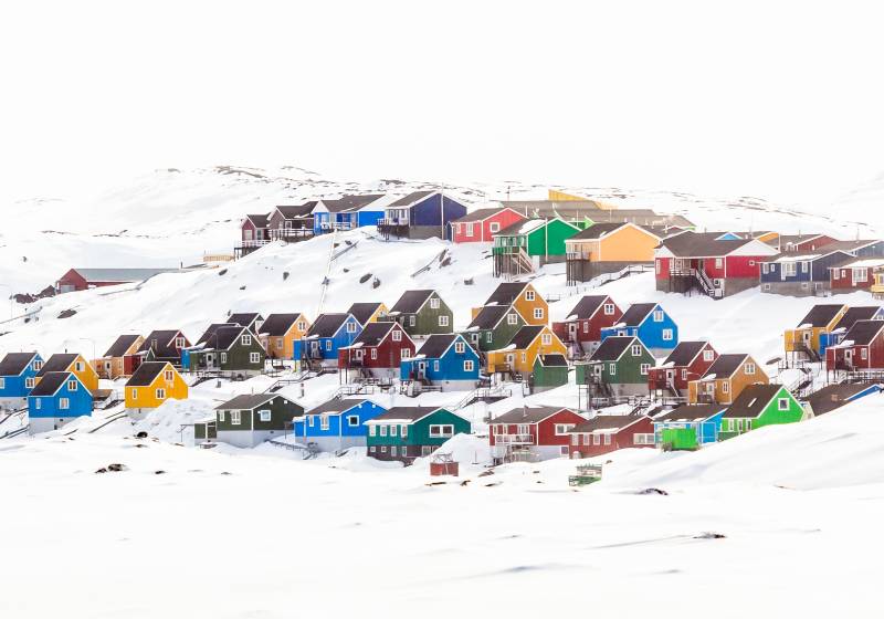 Multiple colorful Inuit houses and cottages on the hill covered in snow Aasiaat city Greenland Arctic