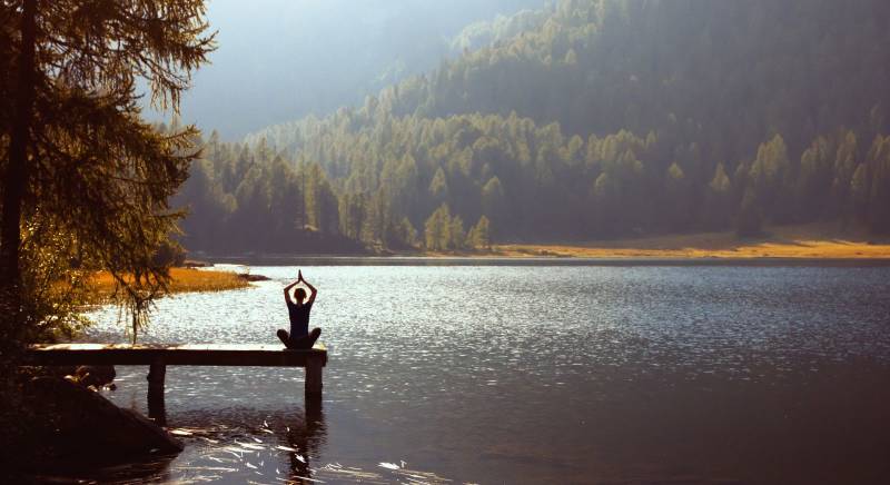 Person beim Yoga am See