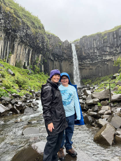 Two people standing in front of a waterfall in Iceland