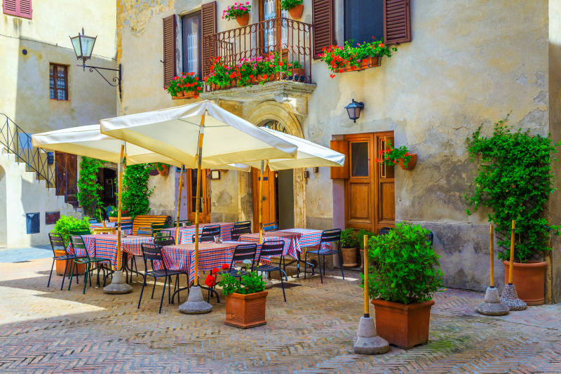 Cozy street cafe and restaurant decorated with colorful flowers, Pienza, Tuscany, Italy, Europe
