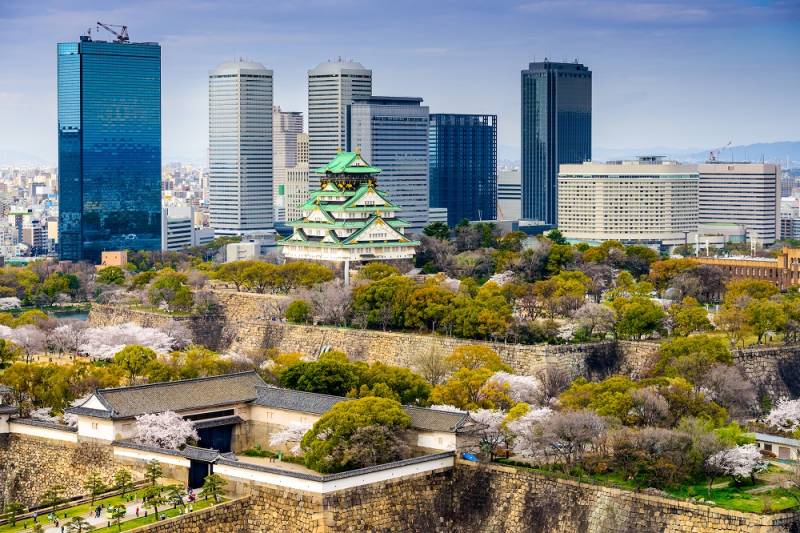 Enchanting Travels Japan Tours Osaka Japan city skyline at the castle and business park in the spring.