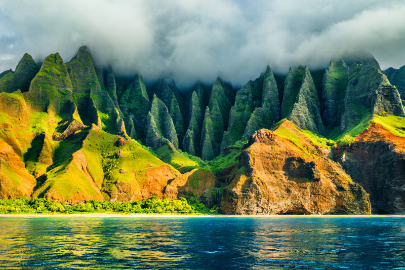 Na-Pali-coast-Kauai-Hawaii-view-from-sea-sunset-cruise-tour.-Nature-coastline-landscape-in-Kauai-island-Hawaii-USA.-Hawaii-travel.