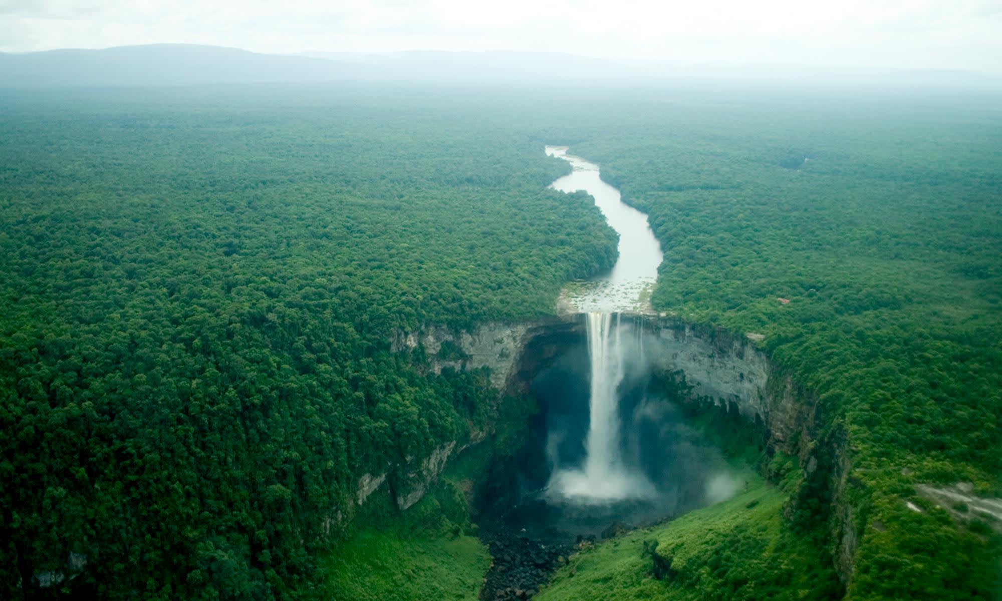 A very tall waterfall in the middle of a mountain photo – Free