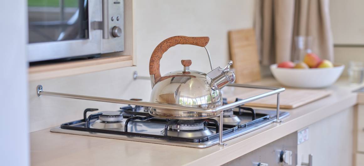 Modern kitchen interior of the Vision 4 featuring a kettle on the stove, sink, and wooden finishes.
