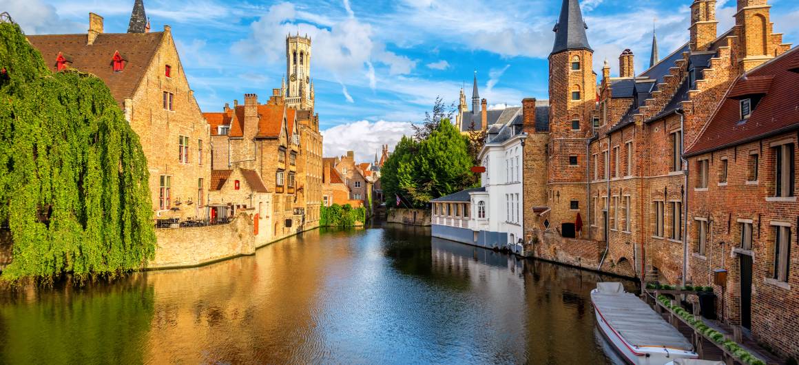 Panoramic landscape of Bruges with historic buildings and canal, explore iconic medieval sights in Belgium.