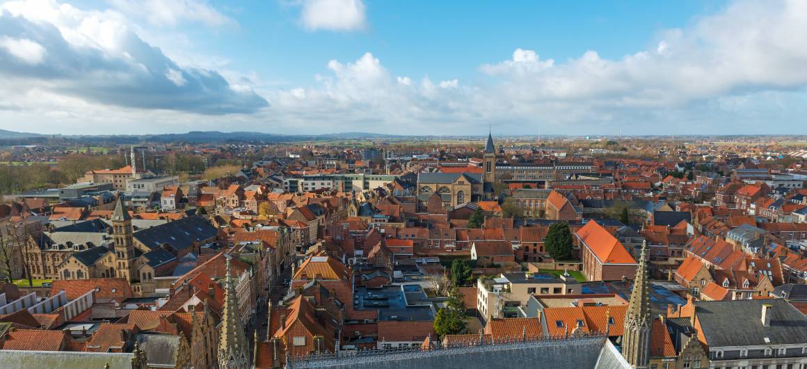 Panoramic rooftop view of Ypres with church spires and bell towers, cultural heritage of Flanders, Belgium.