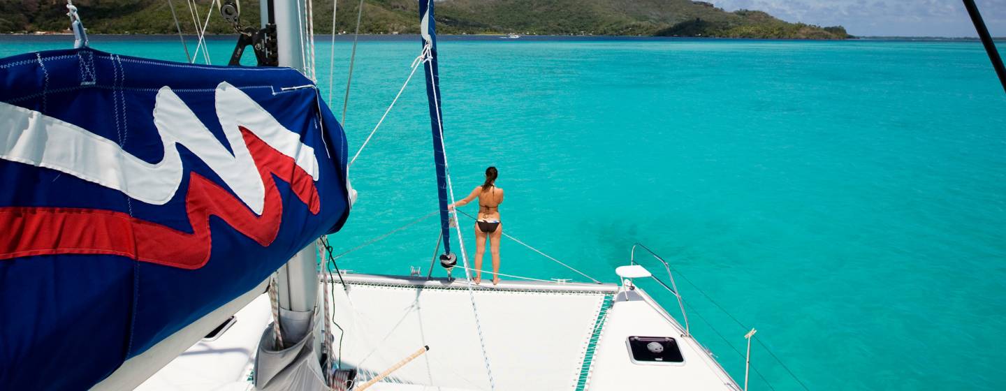 Woman on sailing catamaran trampoline