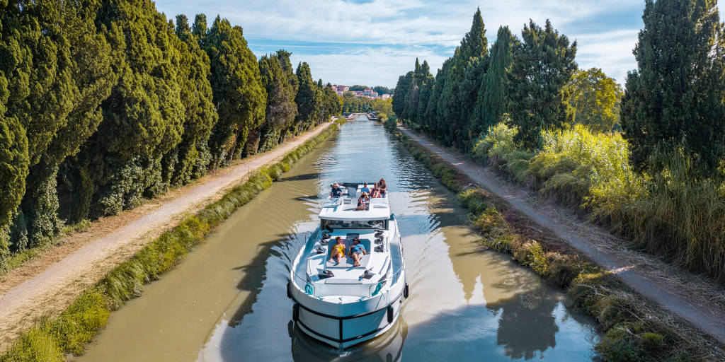 A canal boat cruises the scenic Canal du Midi along the Canal du Midi, offering a relaxing way to explore southern France.