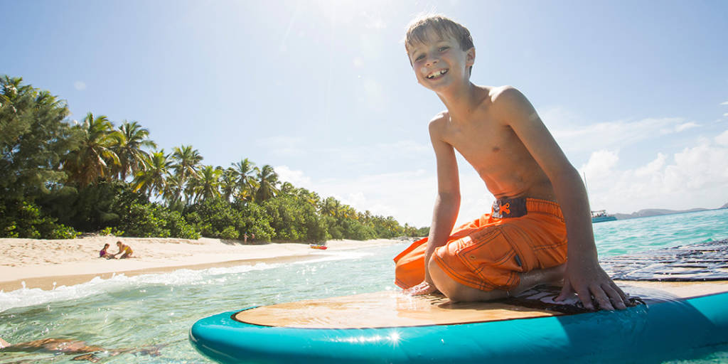 Boy wading on paddle board