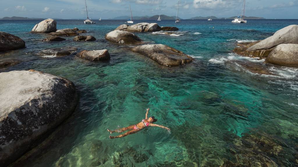 Woman relaxing in the water at The Baths in the BVI