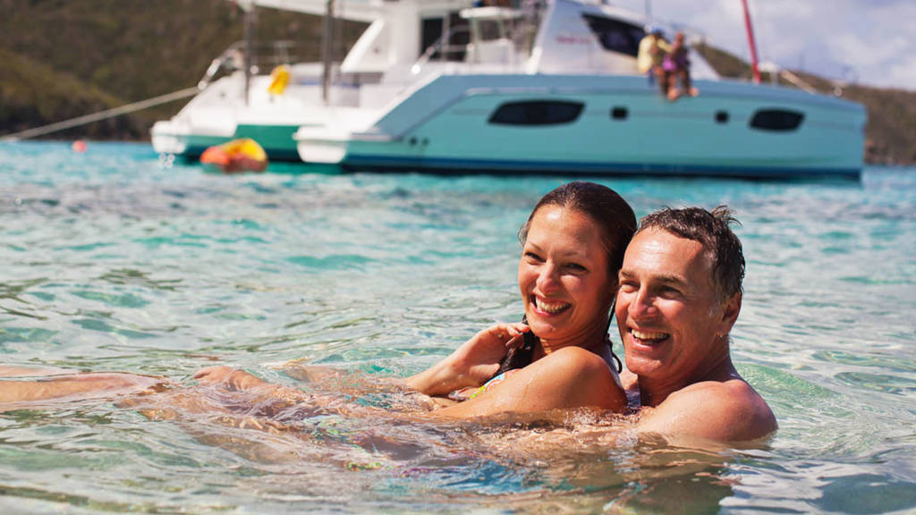 couple-swimming-infront-of-yacht