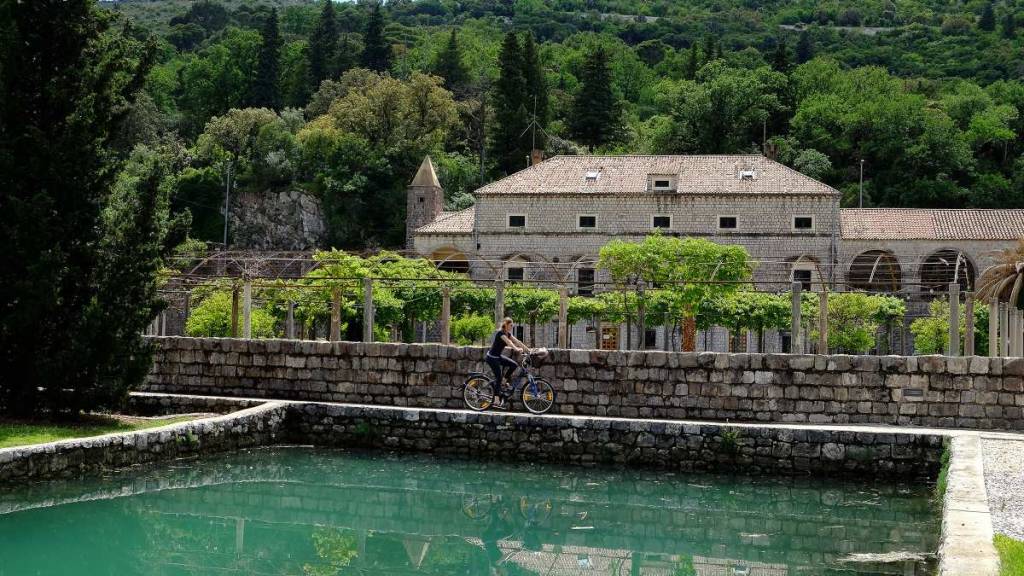 Femme faisant du véo dans un village de campagne en Croatie