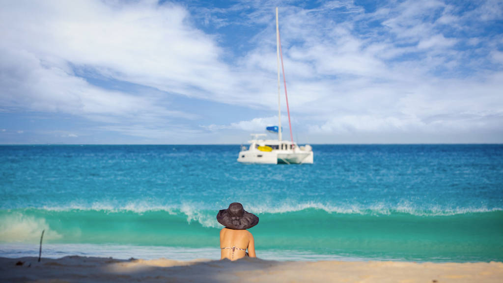 Woman watching yacht on seychelle sea