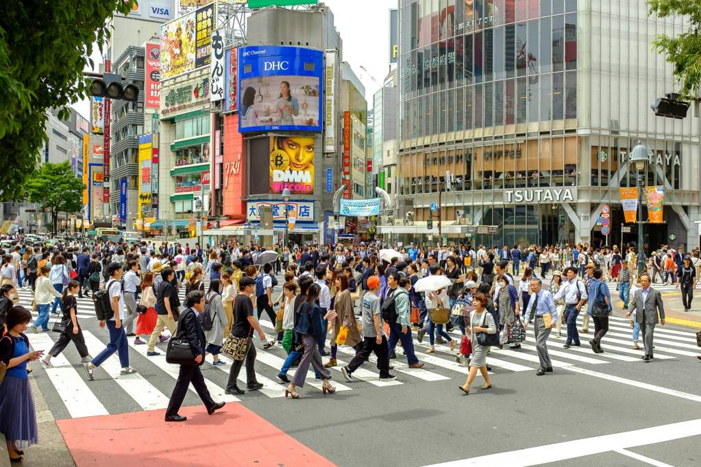 Hunderte Fußgänger überqueren die berühmte Shibuya-Kreuzung in Tokio.