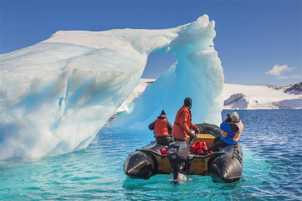 Tourists on a Zodiac exploring the icebergs of the Antarctic Peninsula © Patrick Endres / Getty Images
