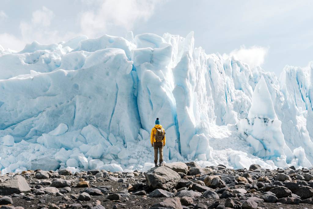 A man standing in front of the Perito Moreno glacier in October which is the best time to visit Argentina